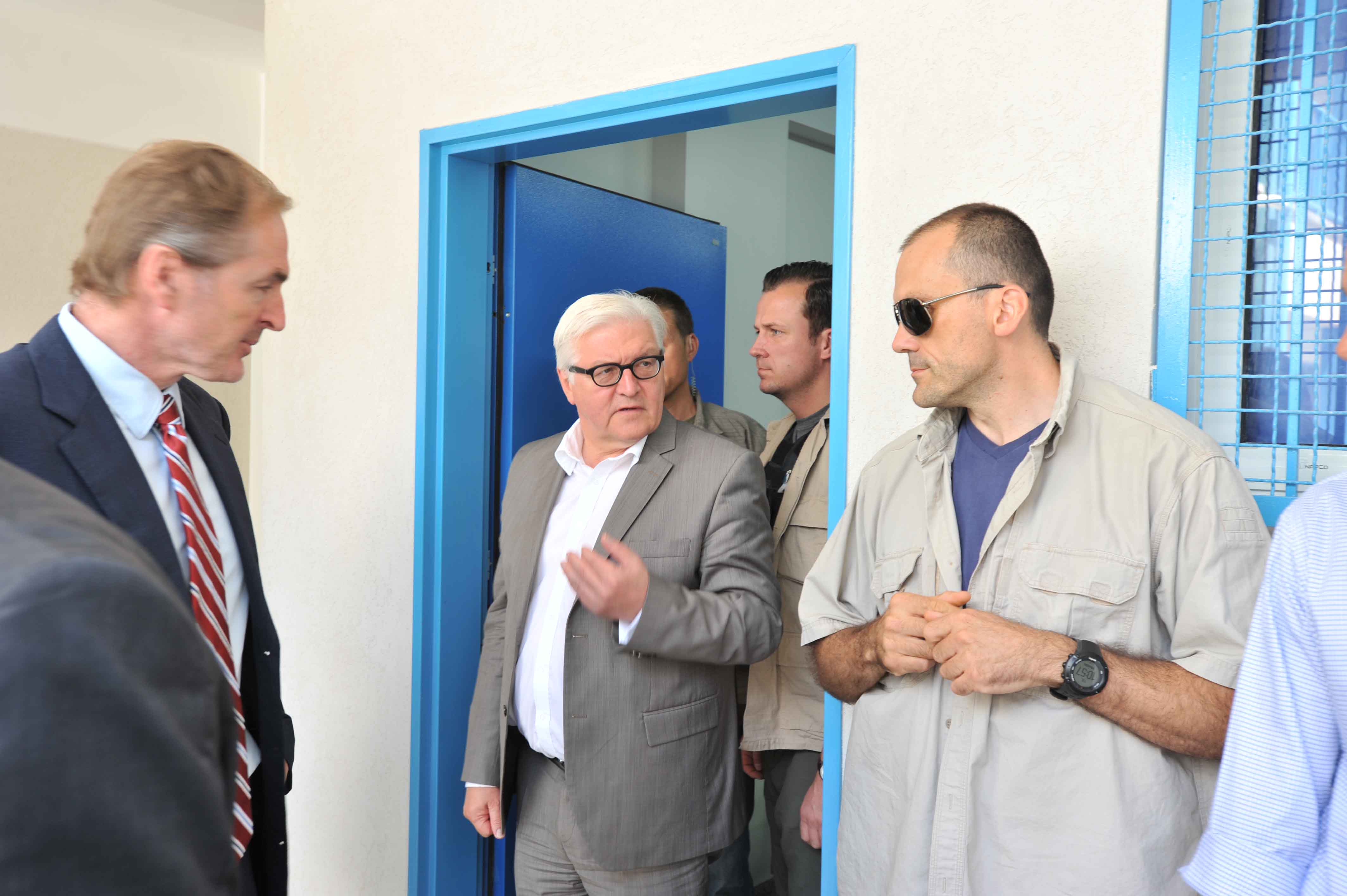 Protective team accompanying an official delegation through a doorway