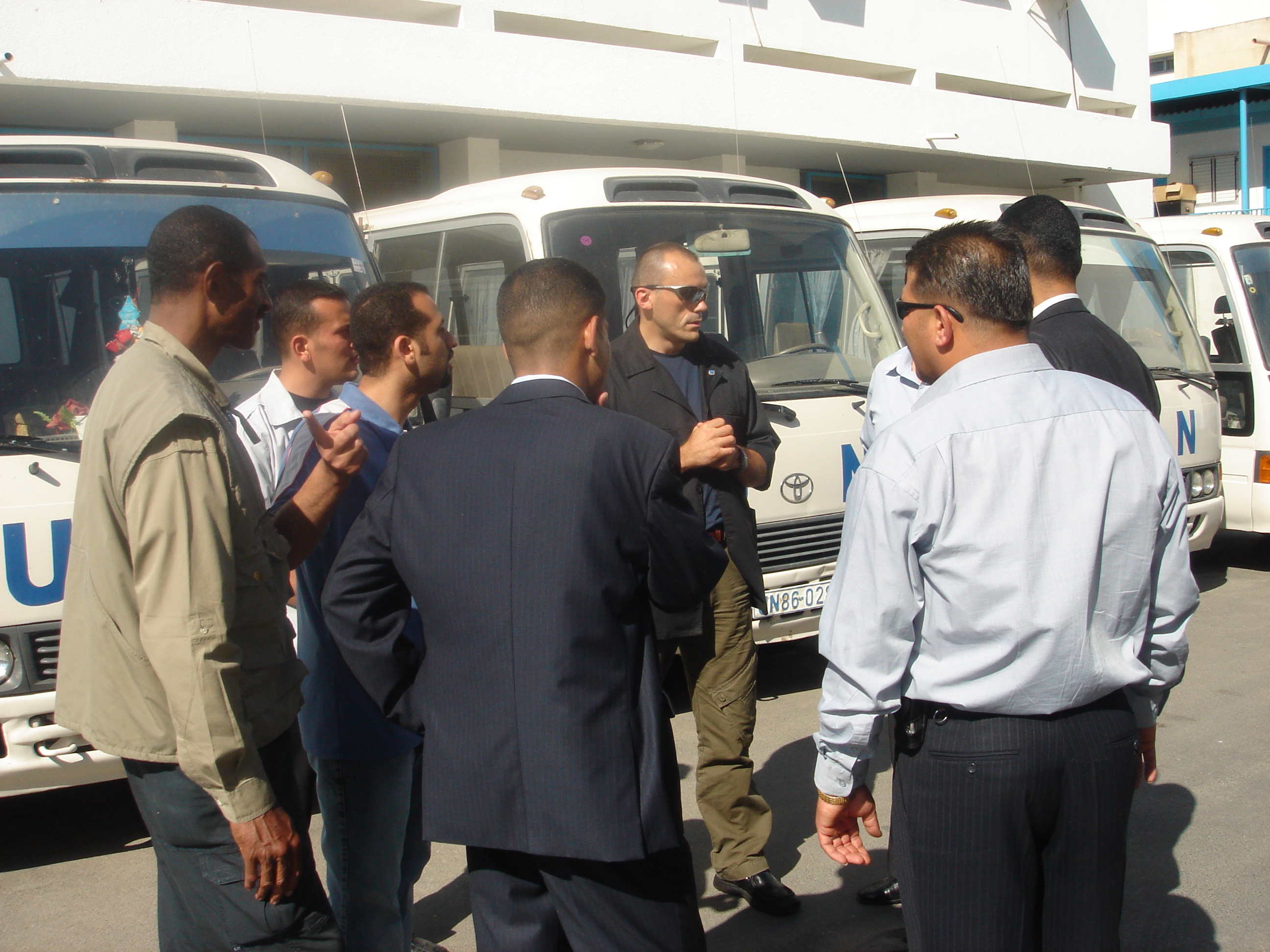 Team briefing beside United Nations minibuses